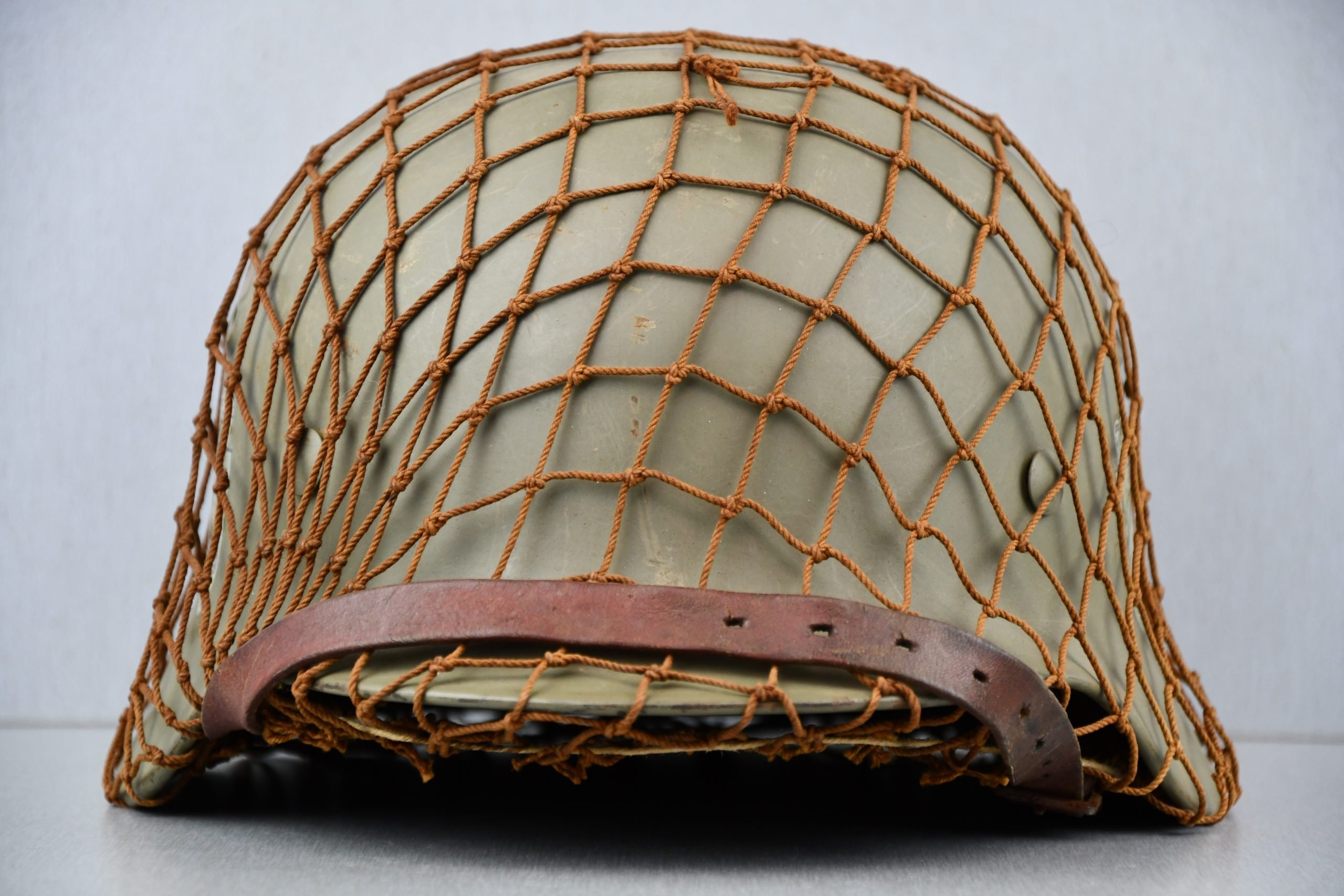 M40 Norwegian reissued steel helmet ET64 with camouflage net — image 4