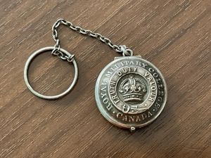 Post 1902 Royal Military College Canada button locket.