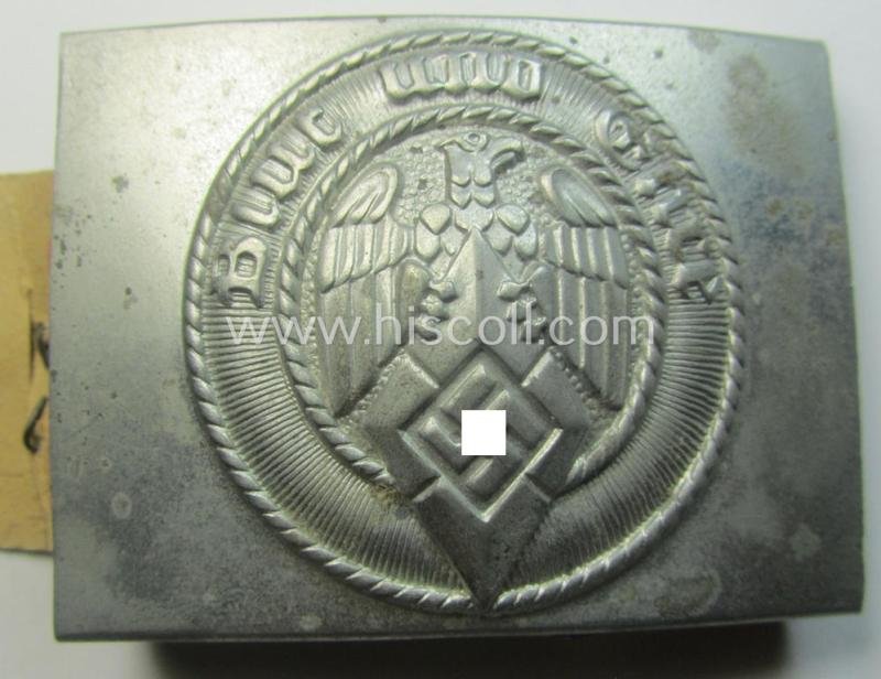 HJ ('Hitlerjugend'), zinc-based belt-buckle being a 'virtually mint' and/or non-maker-marked example having a seldomly seen 'cranked-catch'-set-up and that comes with its period 'RzM'-etiket still attached — image 2