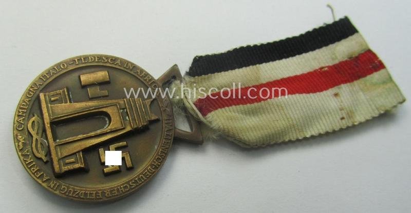 Golden-bronze-coloured- (and I deem 'Buntmetall'-based-) example of a: 'Deutsch-Italienische Feldzugsmedaille' (or: German-Italian campaign-medal) that comes mounted onto its (regular-sized) piece of original (and sun-faded!) ribbon — image 3