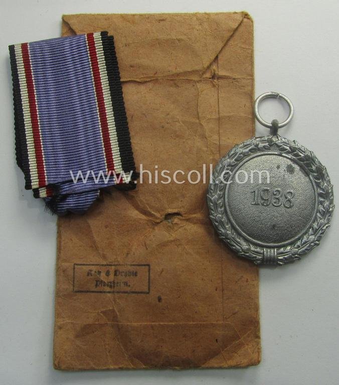 'Luftschutz-Ehrenzeichen 2. Stufe' being a maker- (ie. '10'-) marked example, as executed in zinc-based metal (ie. 'Feinzink') and that comes stored in its (scarcely seen!) 'Zellstoff'-based pouch by the maker: 'Katz u. Deyhle' — image 5