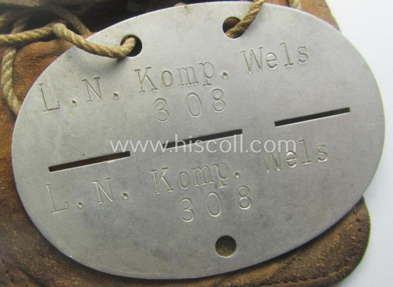 Aluminium-based, WH (Luftwaffe) ie. 'Luftnachrichten'-related ID-disc (ie. 'Erkennungsmarke') bearing the stamped unit-designation that reads: 'L.N. Komp. Wels' and that comes stored in its period (leather-based) pouch — image 2