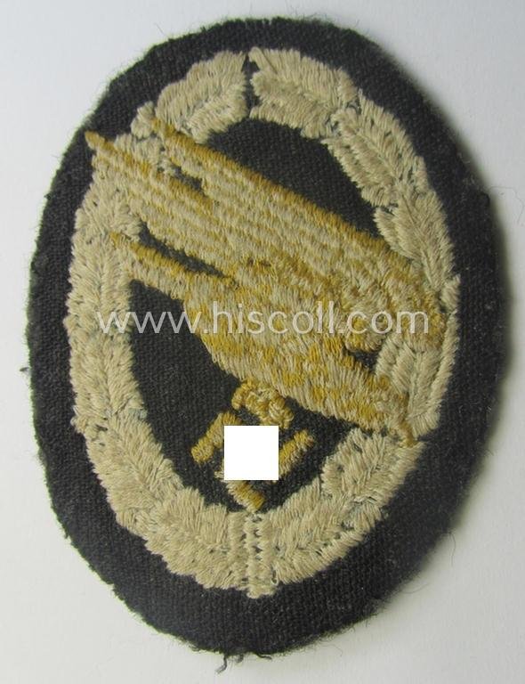 WH (Luftwaffe) 'Fallschirmschützen-Abzeichen in Stoff' (or: cloth-based paratroopers'-jump-badge) being a nicely machine-embroidered specimen that comes in a just moderately used- ie. carefully tunic-removed, condition — image 2