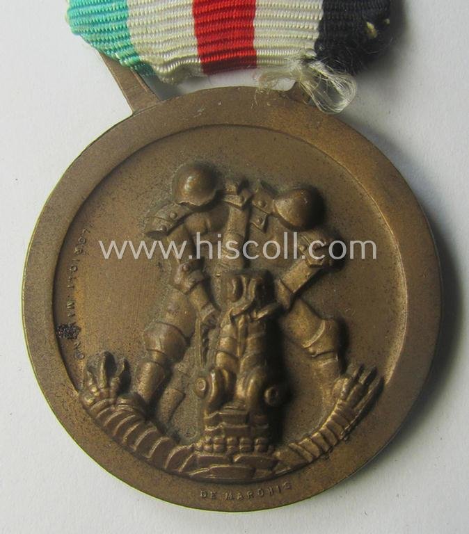 Golden-bronze-coloured- (and I deem 'Buntmetall'-based-) example of a: 'Deutsch-Italienische Feldzugsmedaille' (or: German-Italian campaign-medal) that comes mounted onto its (regular-sized) piece of original (and hardly faded!) ribbon — image 2